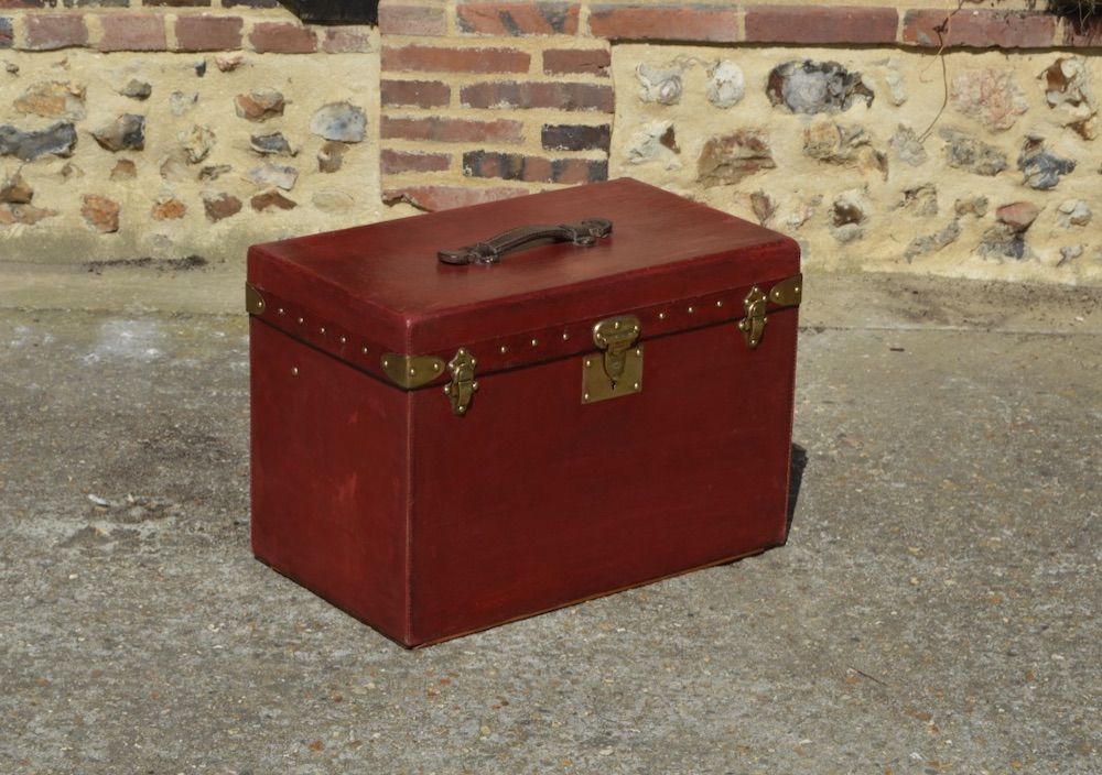 A RED GOYARDINE CANVAS HARDSIDED GRAND HOTEL TRUNK SUITCASE